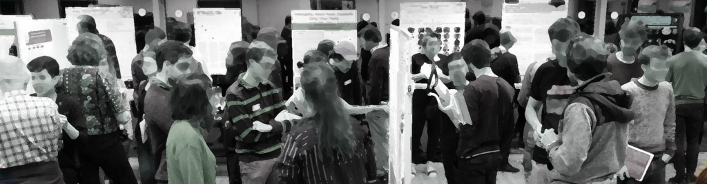 A greyscale photo of people in a room full of scientific posters. Some people are talking, others are looking at the posters. Details are blurred.